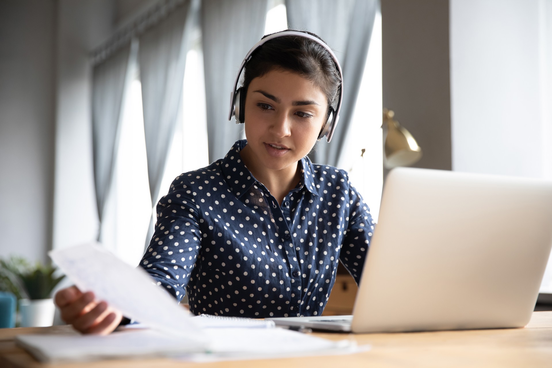 Indian student wear headphones talk to e-tutor by videocall