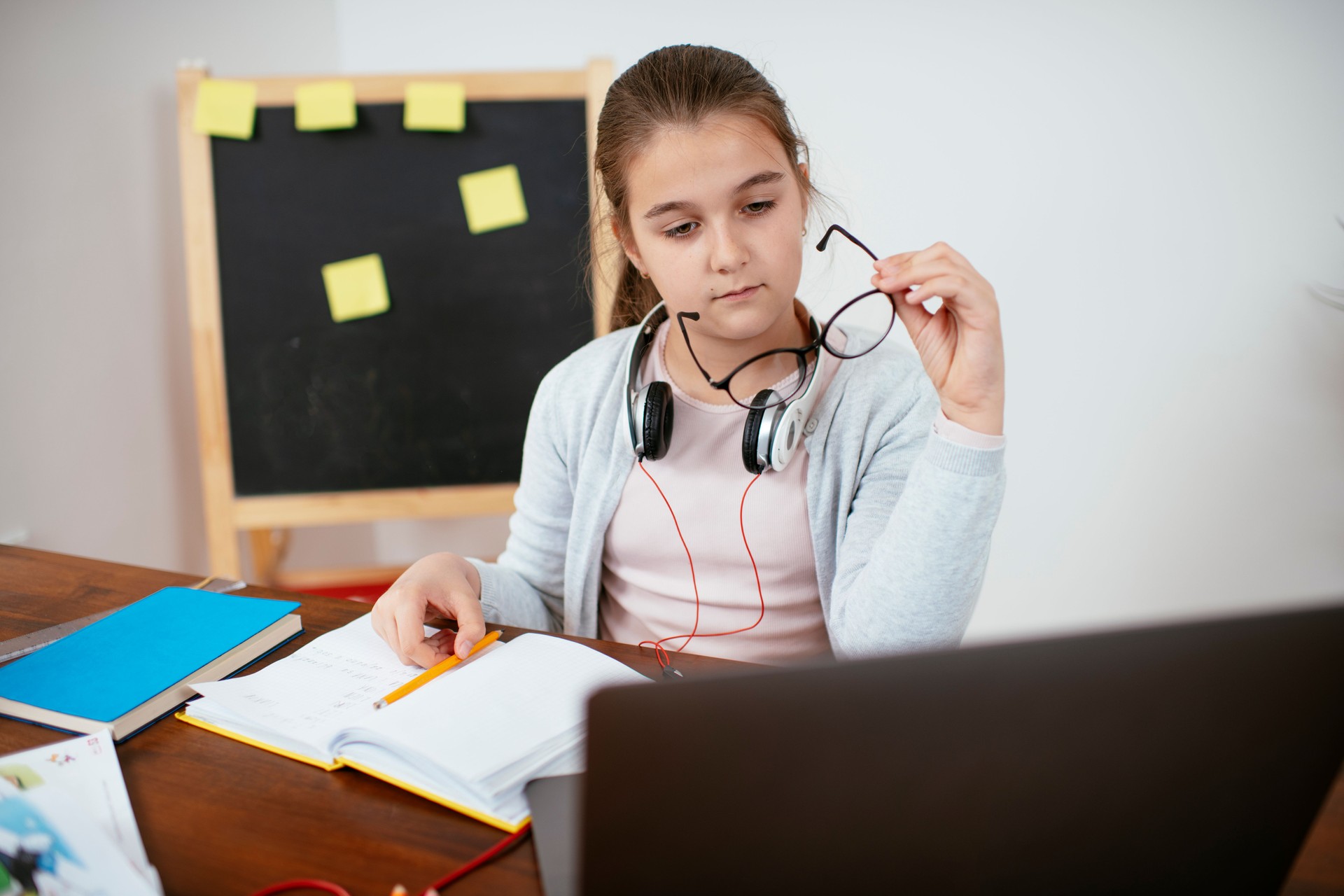 Teenage girl using laptop for homework stock photo